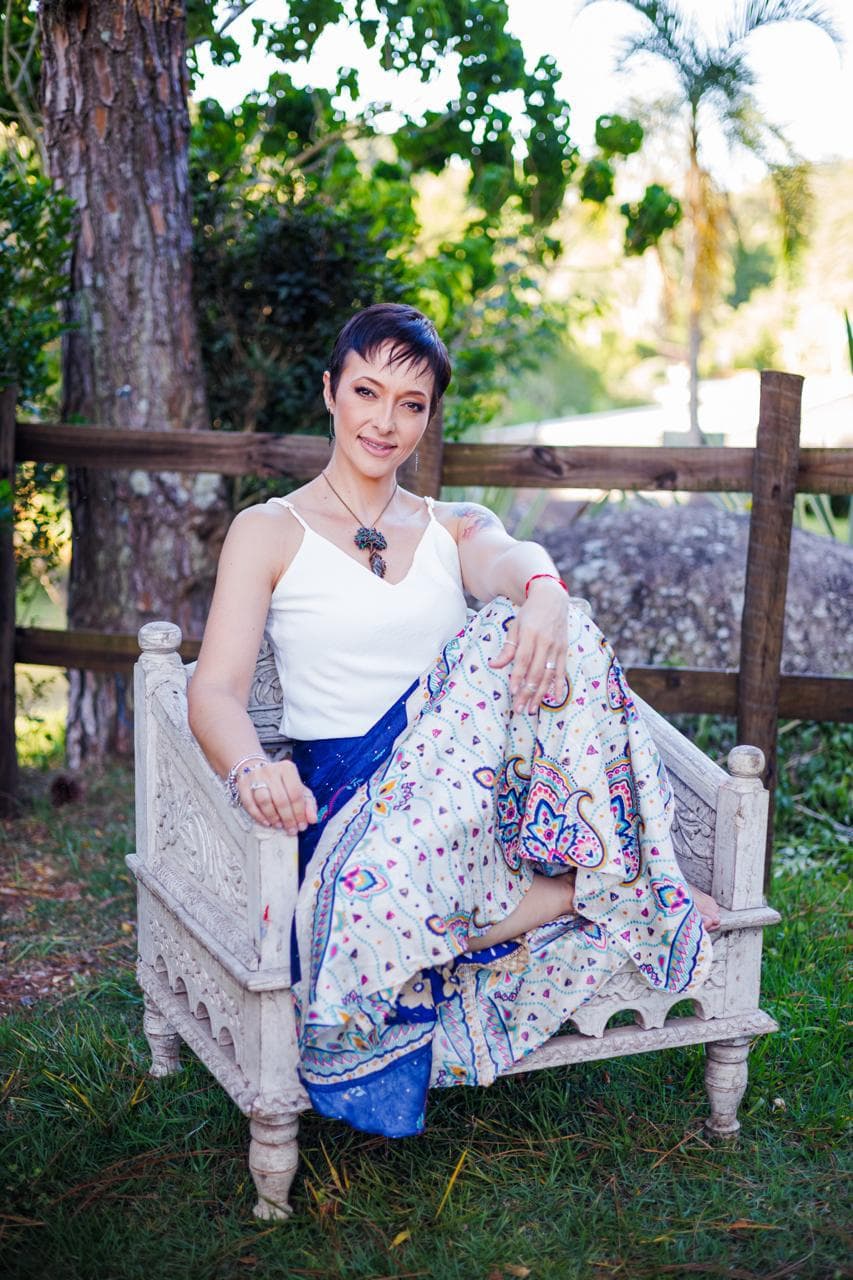 Camila Santana sentada em ambiente natural