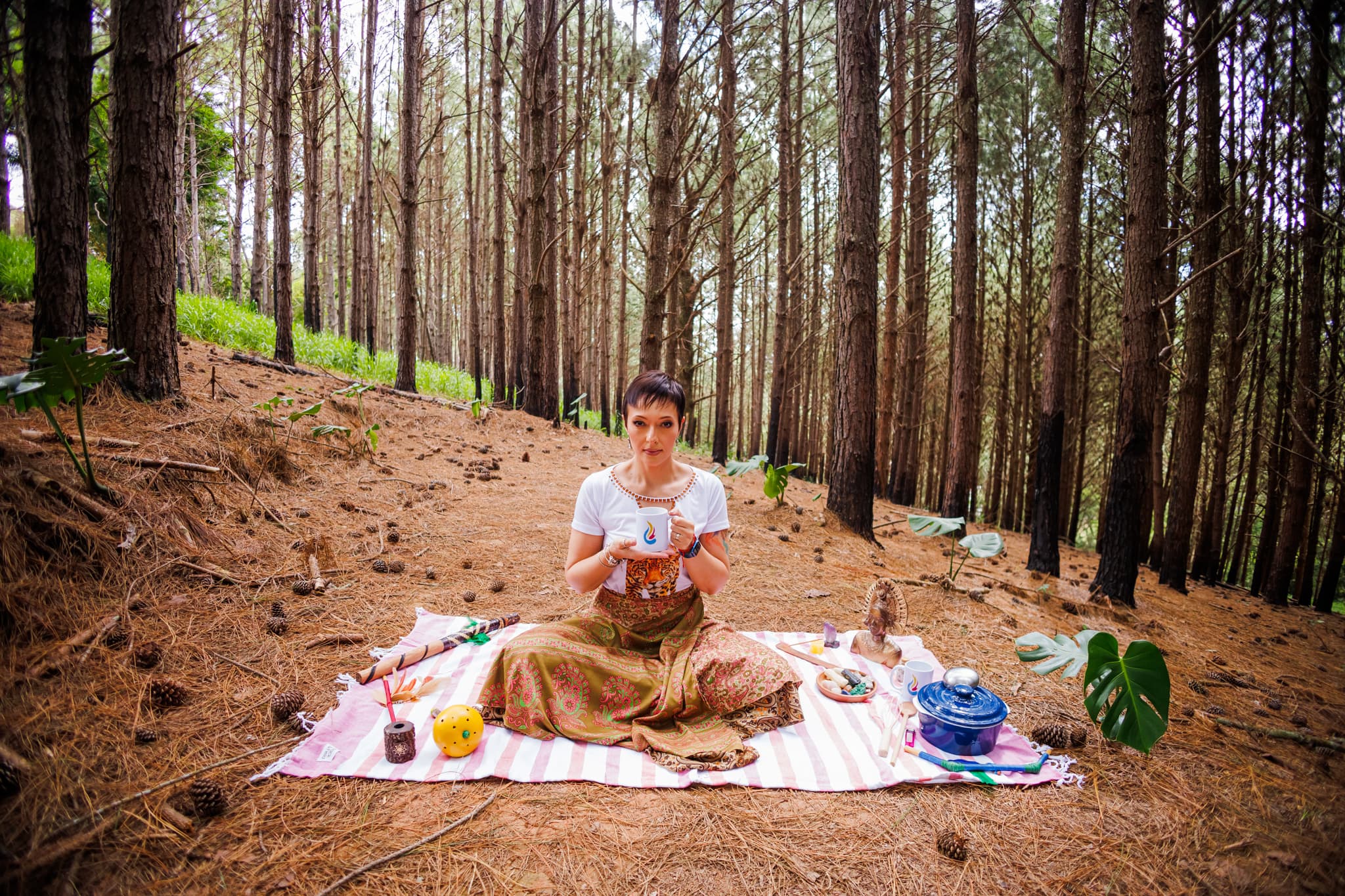 Camila Santana em uma floresta segurando uma xícara de cacau